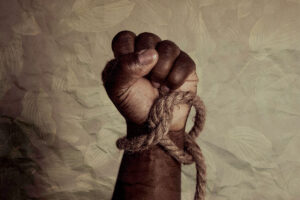 A black fist with a thick brown rope tied around the wrist