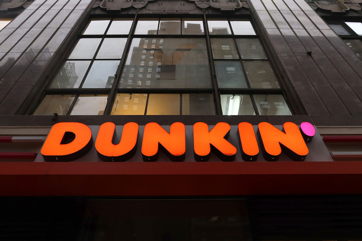 The orange Dunkin' logo see on a big brown building.