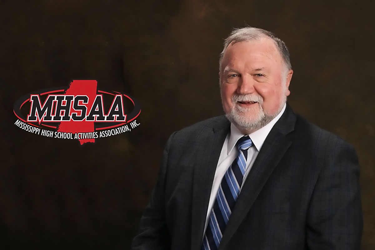 Rickey Neaves poses in front of a brown backdrop. The red and black logo for Mississippi High School Activities Association is overlayed on the left.