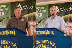 Split image showing Tate Reeves and Brandon Presley both speaking at a podium at the Neshoba County Fair
