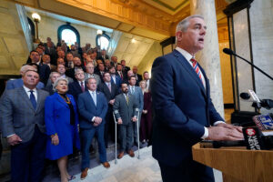 a photo of House Speaker Gunn at a podium with dozens of Republicans lined up behind him on the steps in the Capitol rotunda