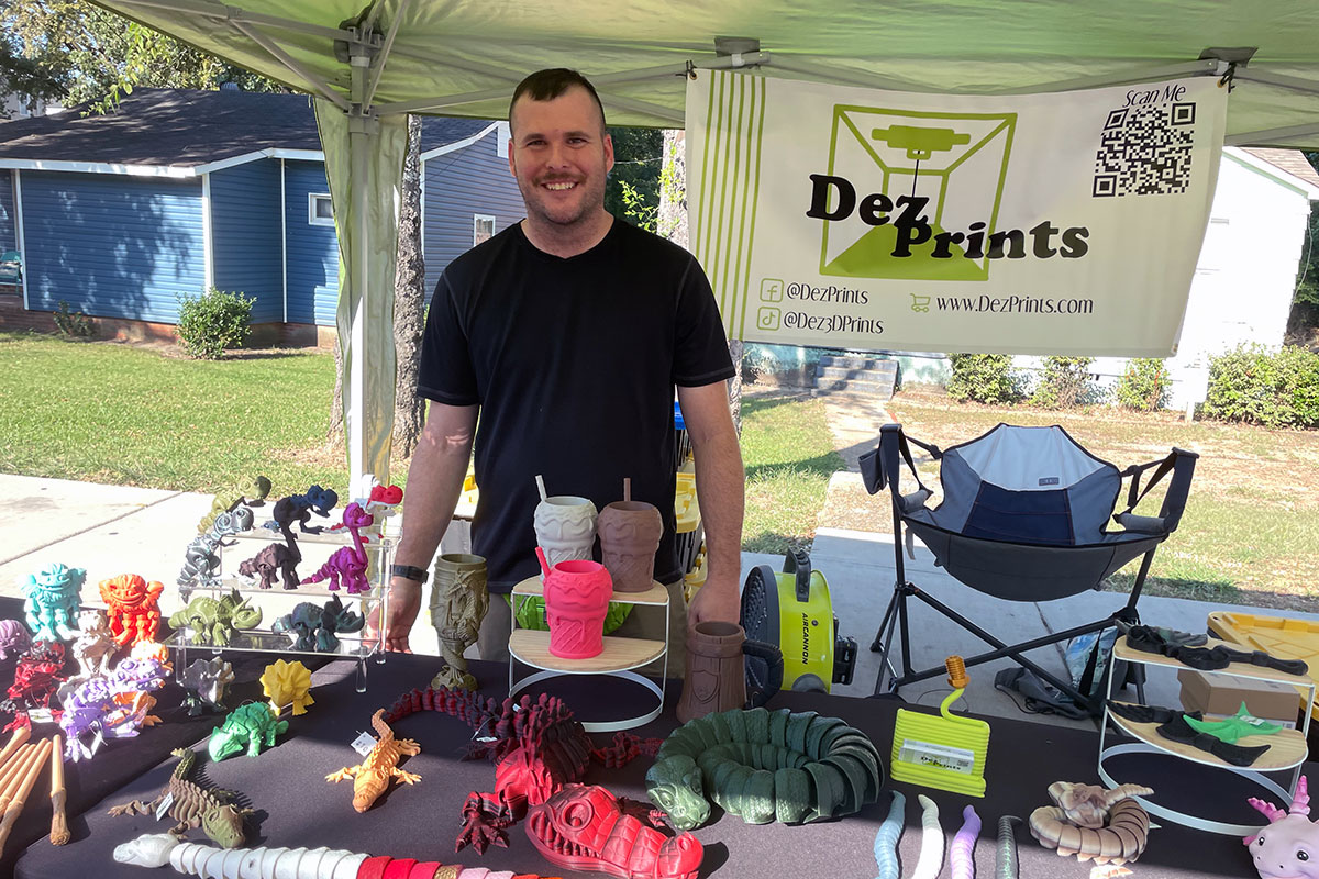 Desmond Longnecker stands at his booth of 3d printed items