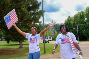 Two women wearing shirts with US flags and carrying signs with the same that read "Abortion Freedom Fighters"