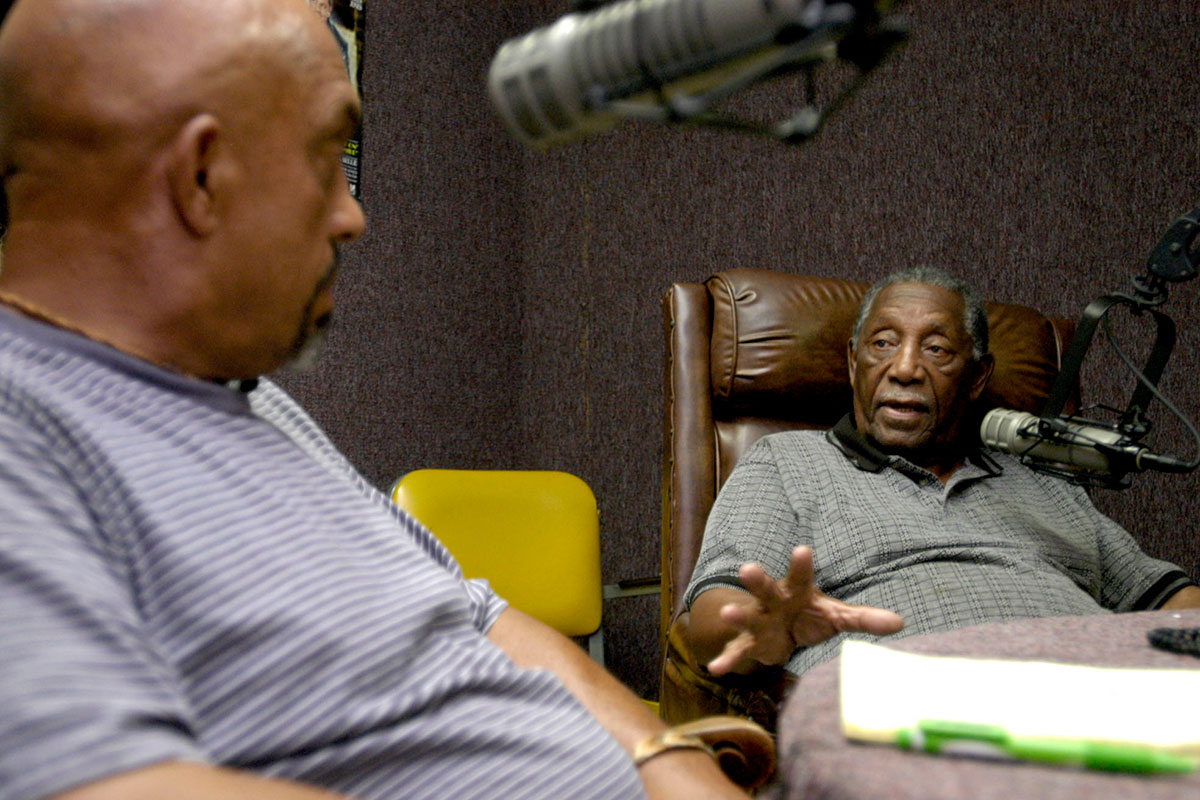 Charles Evers and Thomas Moore sit in a recording studio and talk to each other in front of mics