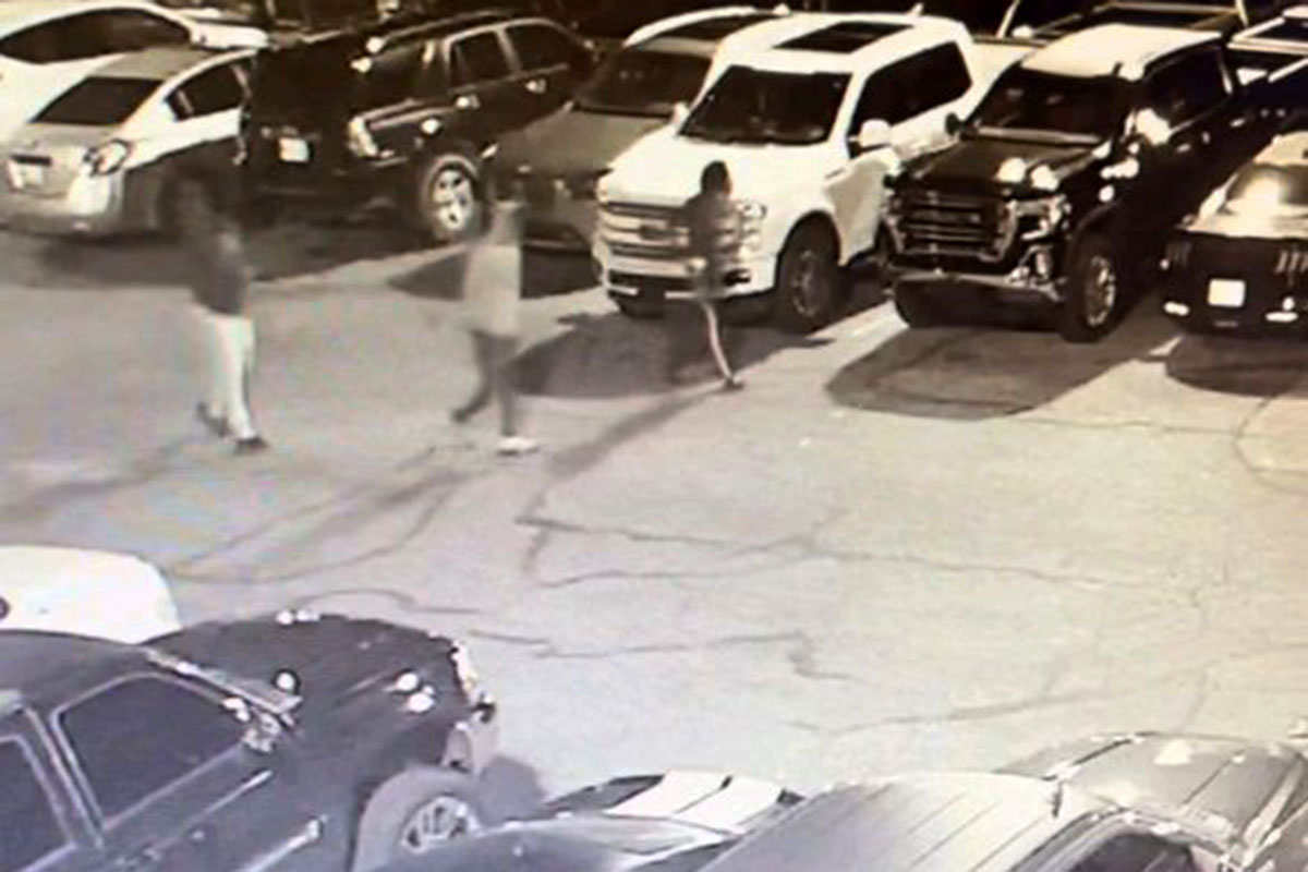 Security footage of three people walking through a parking lot
