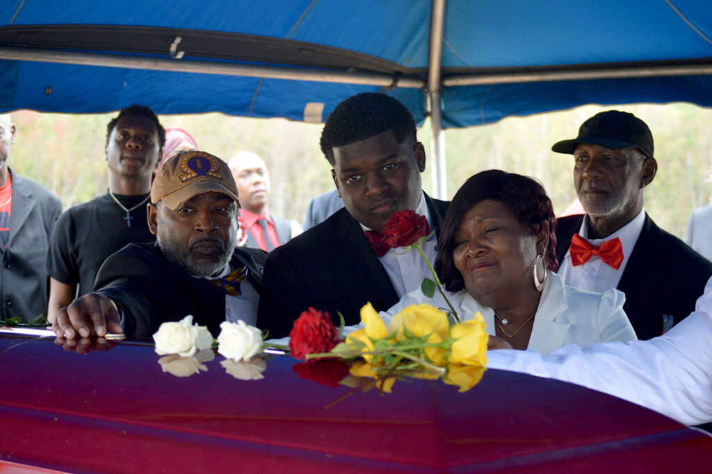 Dexter Wade’s mother and uncle places flower on casket