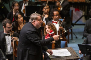 Dr. Gregory Fuller directs the orchestra for a holiday performance