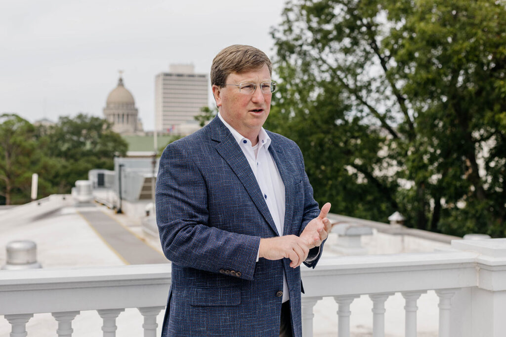 a photo of Gov. Tate Reeves speaking while standing on the roof of the governor's mansion