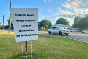A sign reads "National Guard Voting Precinct moved to BusinessPlex (Old Training School)