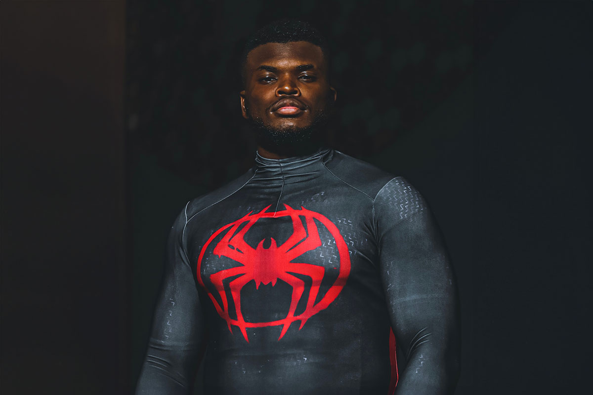 Preston Wallace dressed in a black Spiderman costume with a red spider logo on the chest