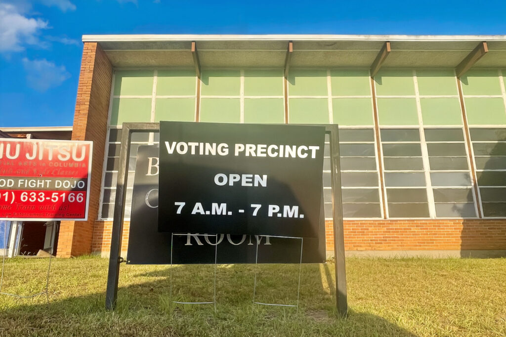 A sign outside of a school that reads "Voting Precinct Open 7 A.M. - 7 P.M.