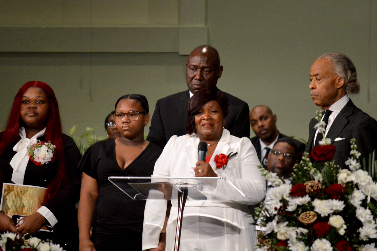 Wade’s mother and daughters on stage with Ben Crump and Al Sharpton at funeral