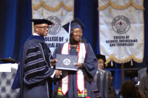Sharita Hansford seen in her Jackson State University Class of 2023 graduation robes receiving her diploma on stage