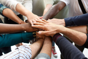 Hands of diverse peoples all stacked in a circle for teamwork