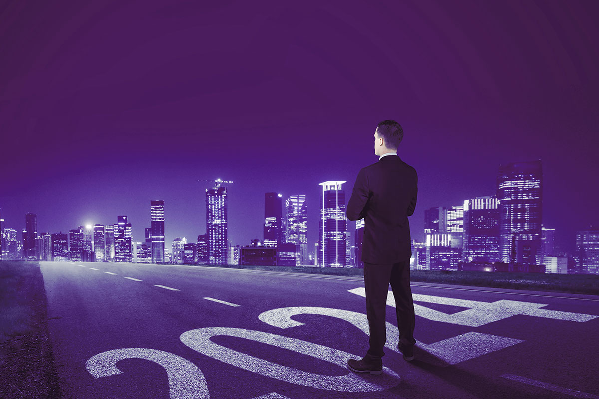 A man standing on a road marked 2024, looking ahead