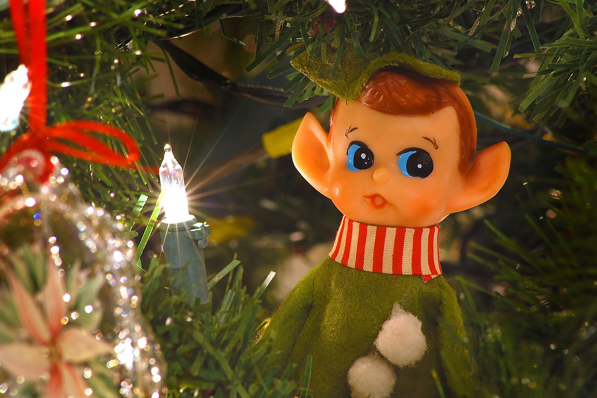 An elf ornament and Christmas light. (Christmas tree)
