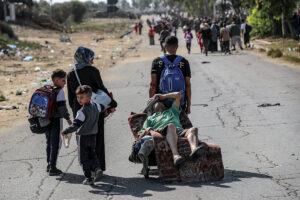 A road is filled with Palestinians fleeing with few belongings on their backs