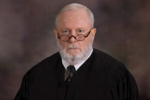 Claiborne “Buddy” McDonald IV seen in glasses and judge robes