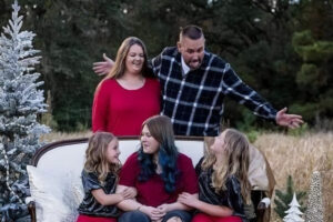 Jeremy Malone seen laughing with his wife and three daughters in a Christmas themed family photo