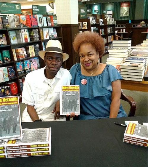 Will McGee and Meredith Coleman McGee holding a book about James Meredith