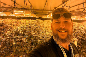 A man taking a selfie inside a marijuana grow room