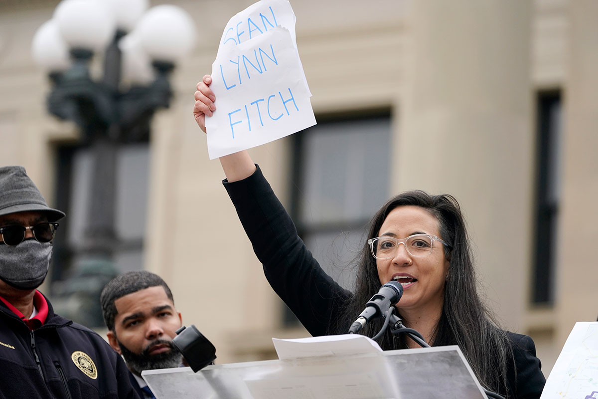 Paloma Wu with the Mississippi Center for Justice, waves the names of officials who would appoint new judges and prosecutors if Mississippi House Bill 1020 were to pass