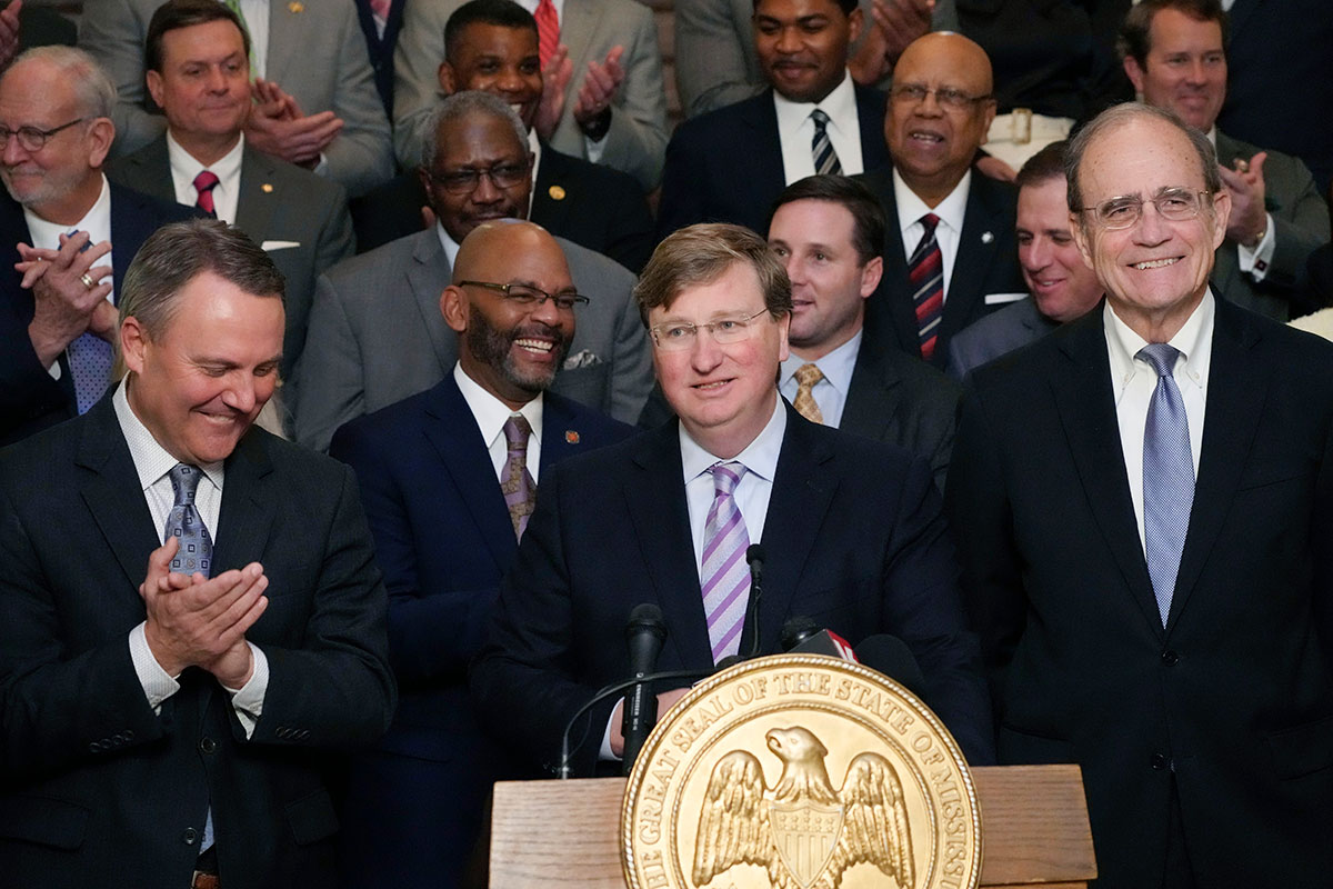 Mississippi Republican Gov. Tate Reeves, center, receives applause from House Speaker Jason White, R-West, left, and Republican Lt. Gov. Delbert Hosemann