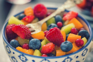 A blue and white bowl filled with a colorful variety of fruit