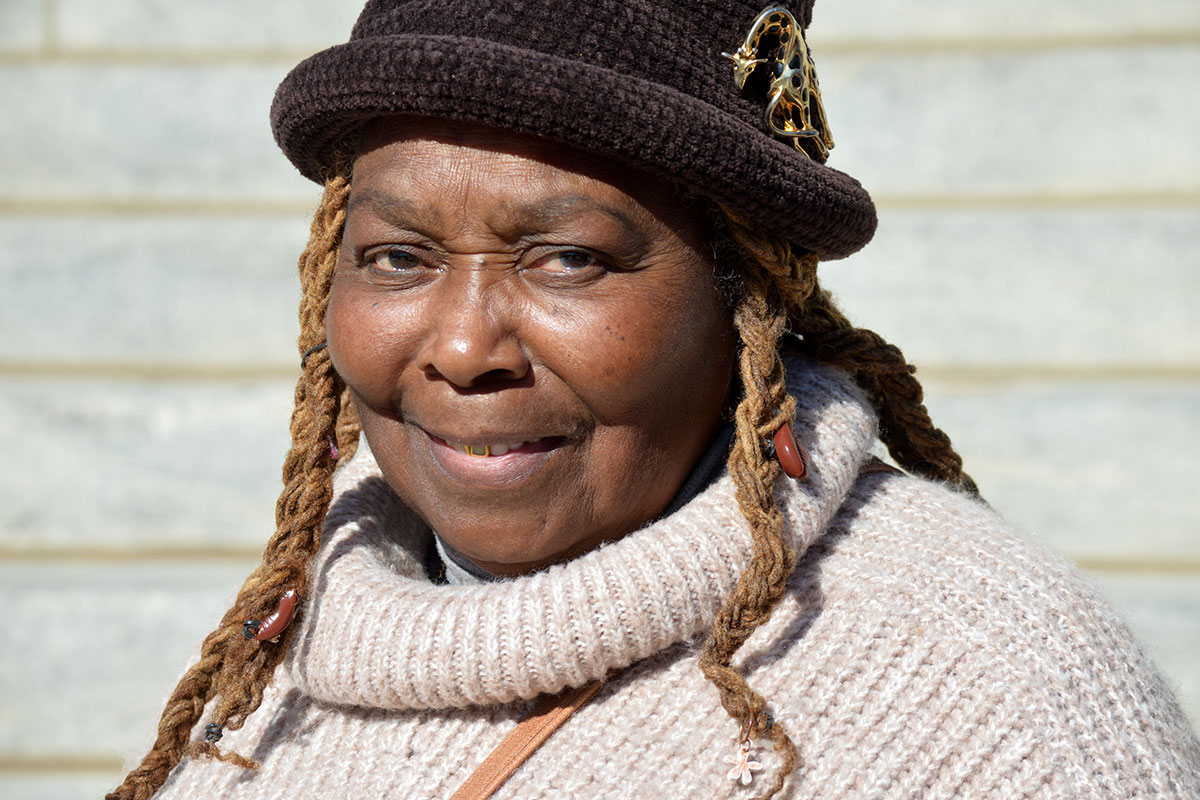 Closeup of a woman in a natural colored sweater and brown hat