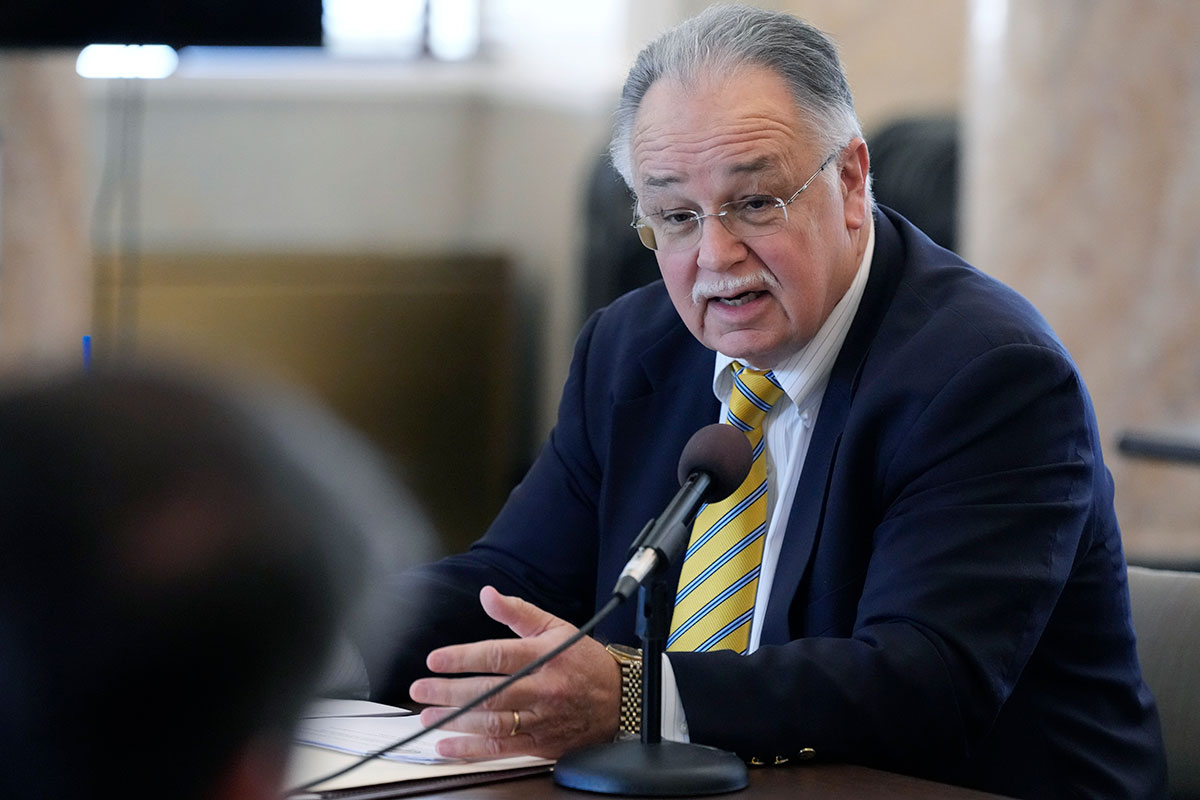 A man speaks at a mic in the legislature