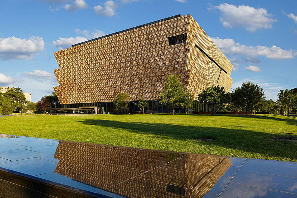 A geometric beige building on a green lawn