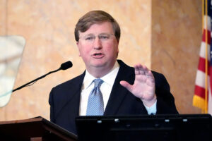 Gov. Tate Reeves delivers speaks from a podium inside