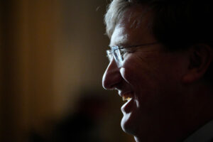 A close up profile shot of Governor Tate Reeves, smiling and looking left