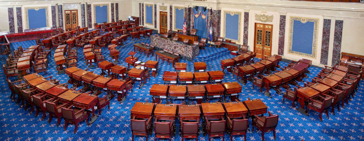 A large room with chairs and desks aligned in a semicircle (the Constitution)