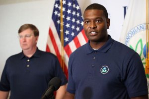 Tate Reeves stands in the background as Michael Regan speaks