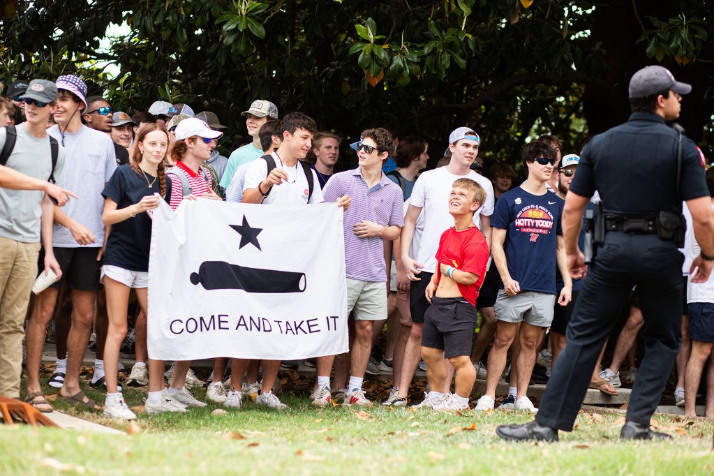 photo shows a group of counterprotestors hlding a sign that says "Come and take it"