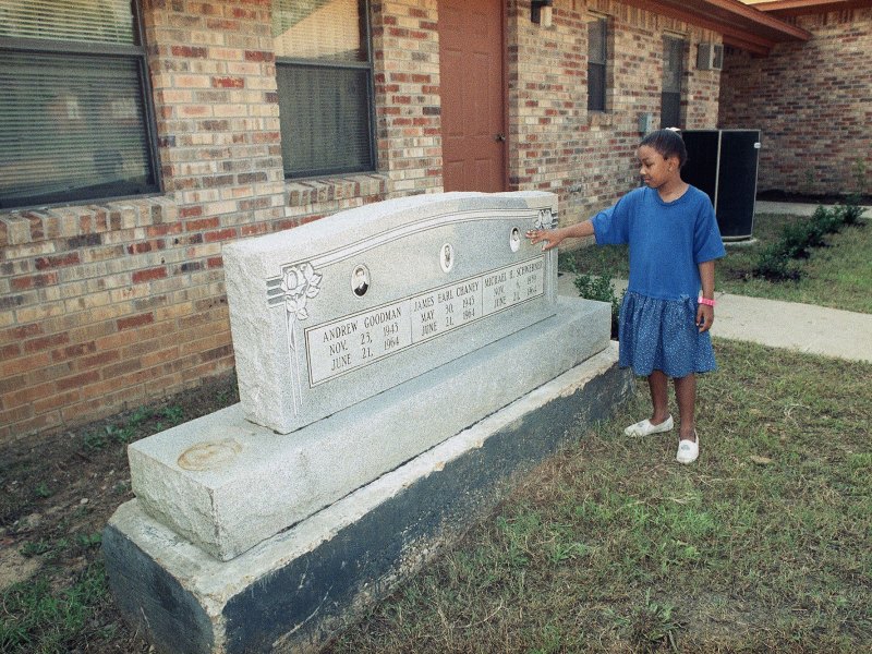 A girl touches a stone monument