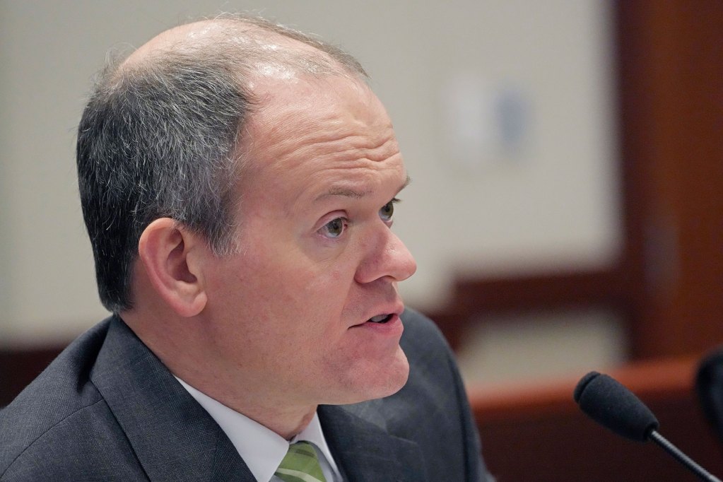 Closeup of a man in a suit speaking into a mic