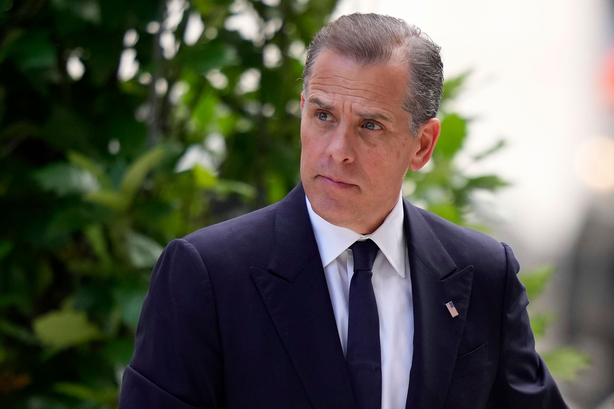 A man in a suit stands outside