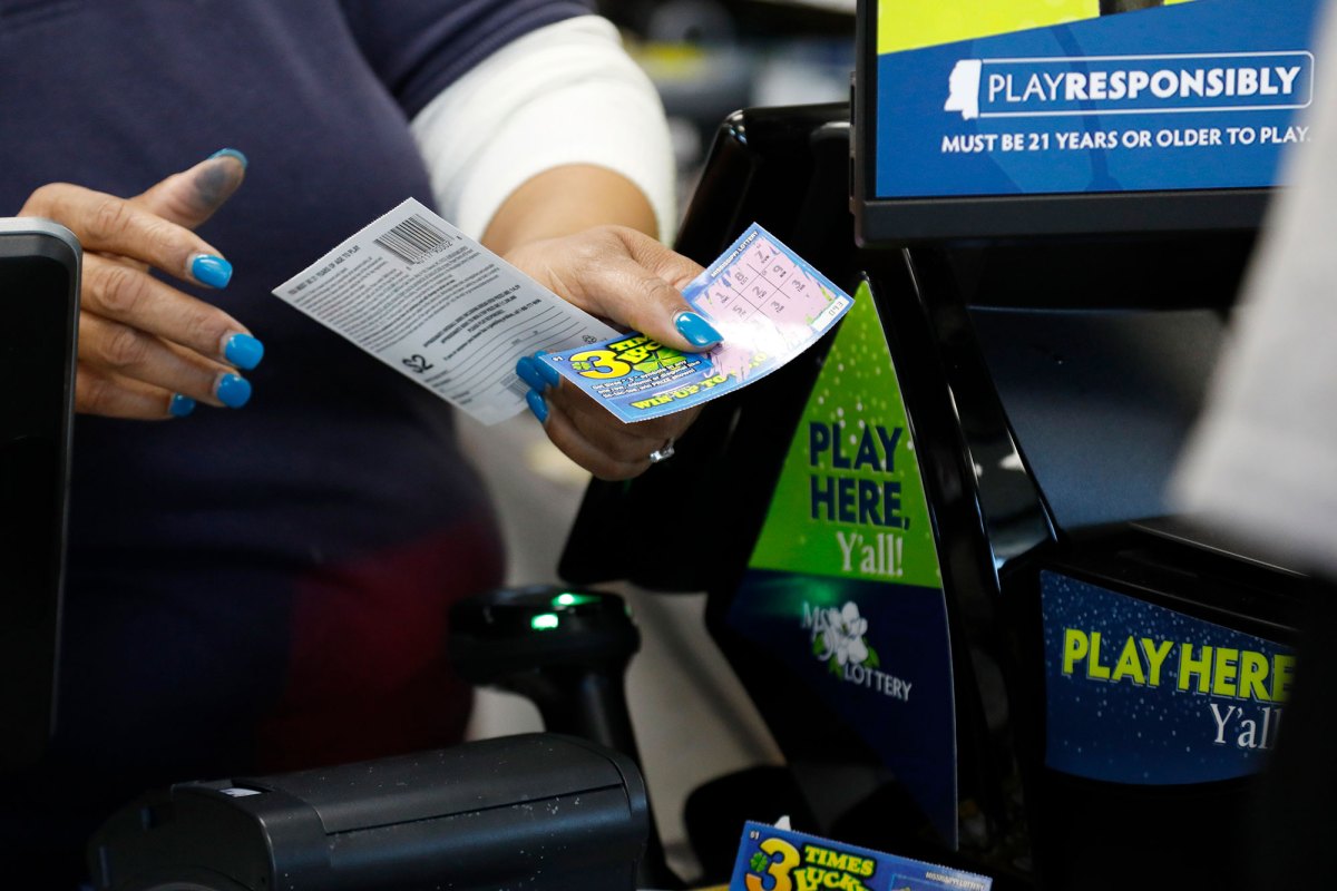 A convenience store clerk gathers winning scratch-off tickets for redemption