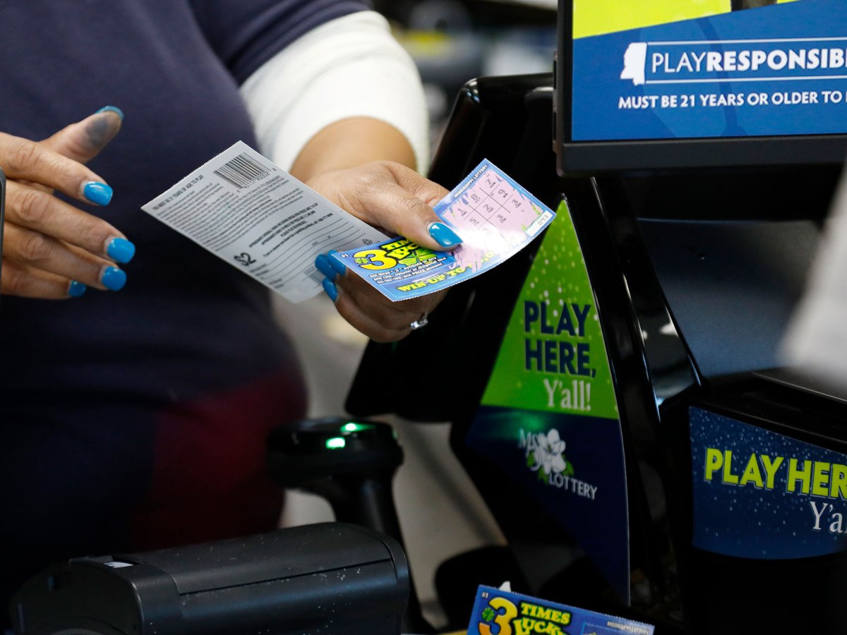 A convenience store clerk gathers winning scratch-off tickets for redemption