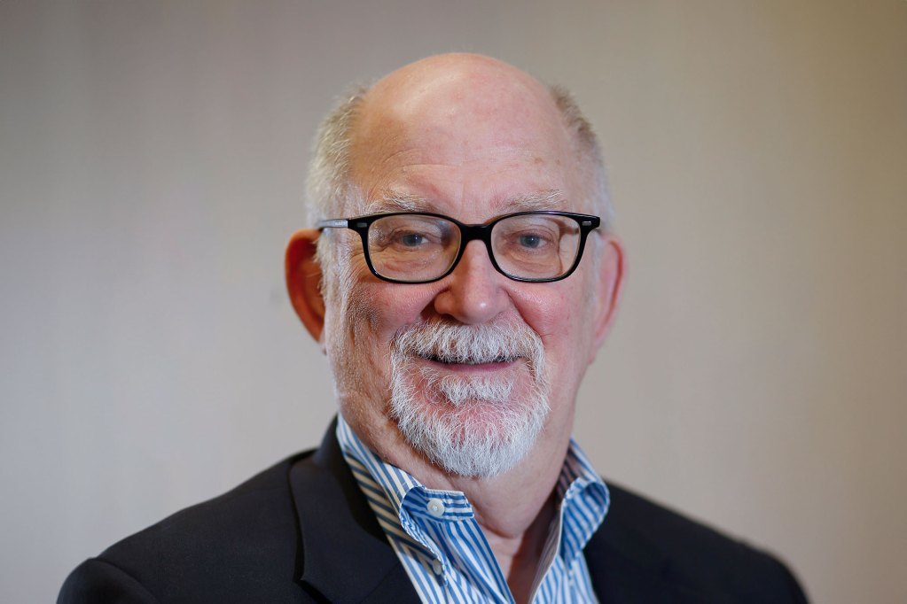 Official headshot of a man in black glasses