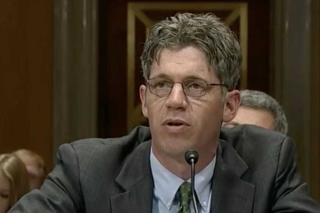 A man in a grey suit speaking at a congressional hearing
