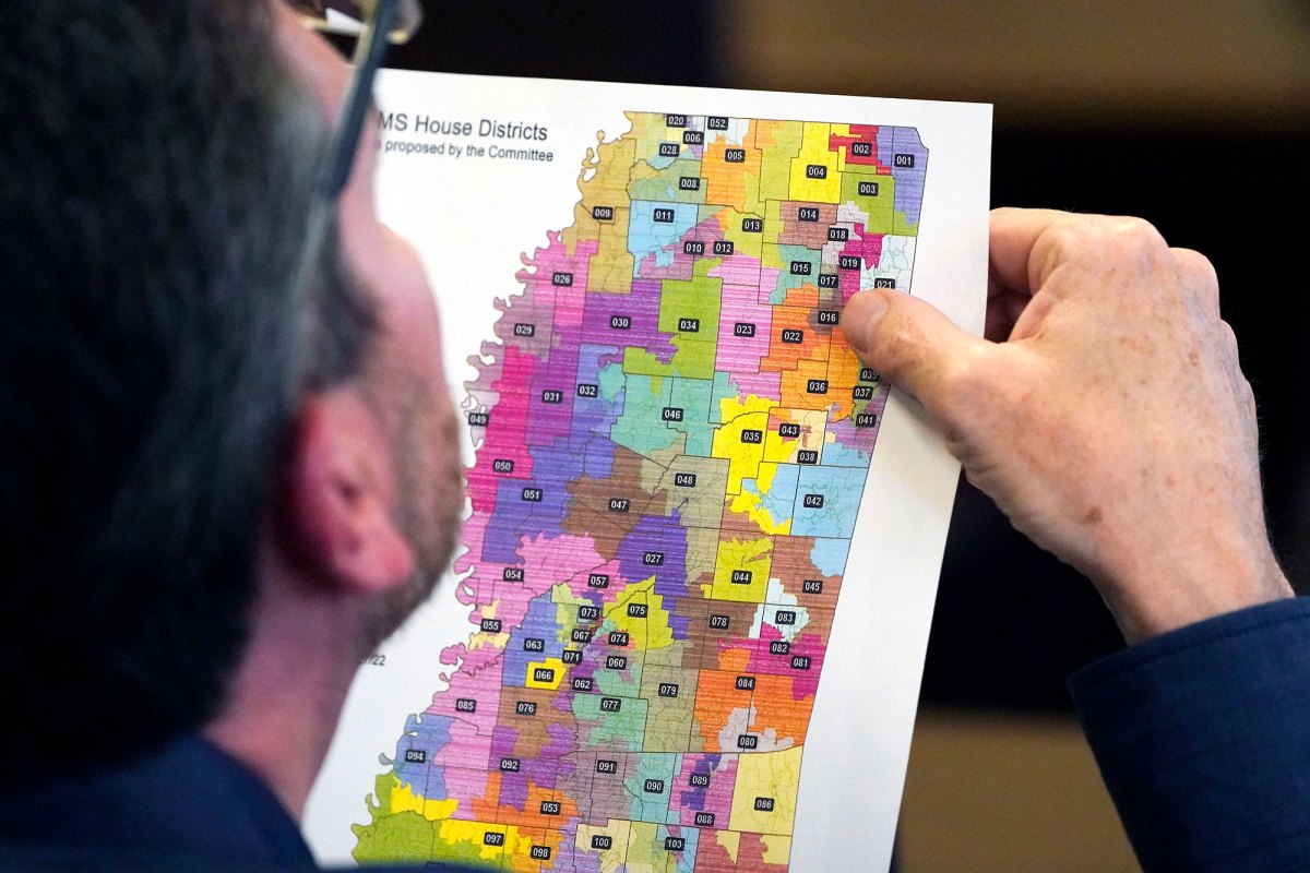 An over the shoulder view of a man looking at a colorful map of Mississippi broken up into many parts