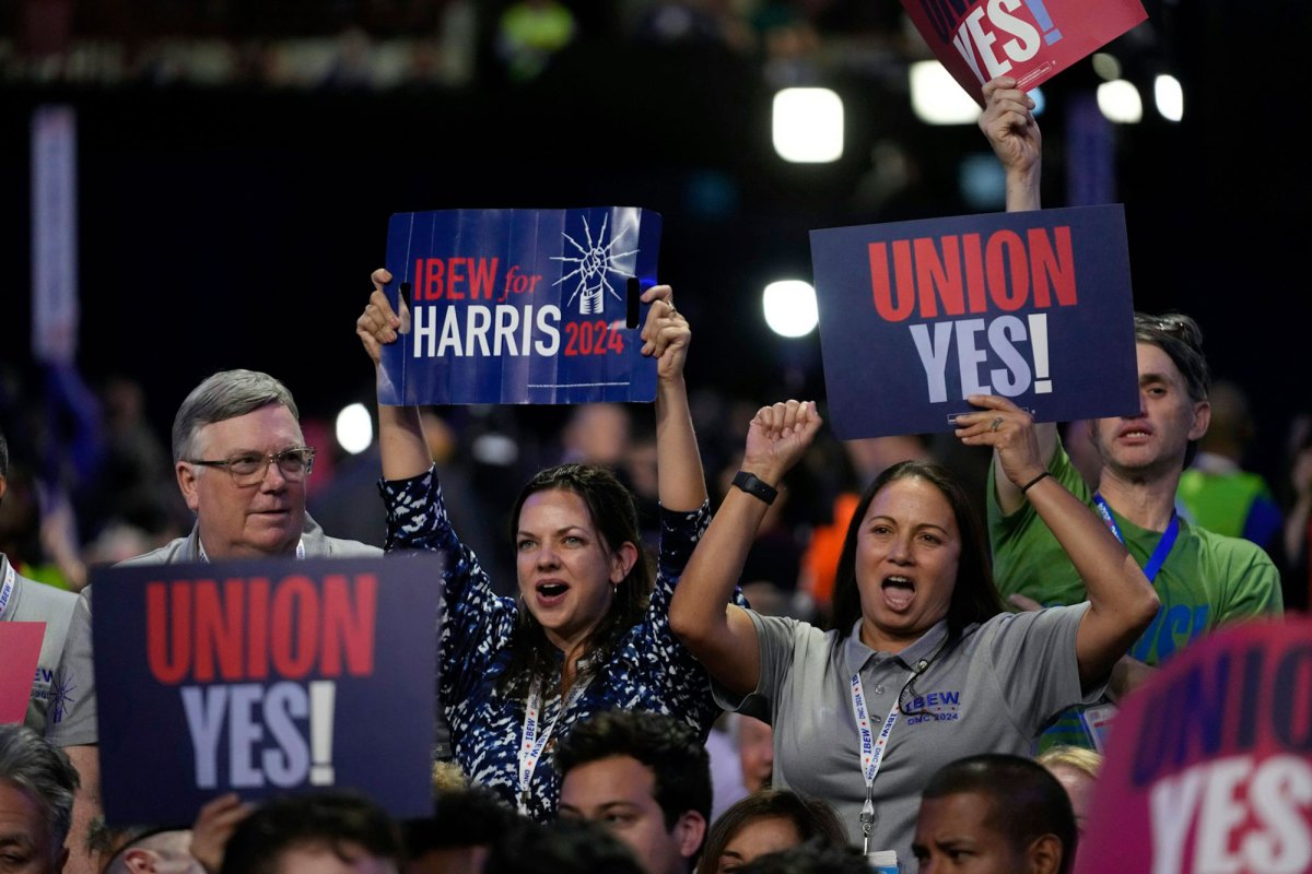 People in a crowd carry signs that read "Union Yes!" and "Ibew for Harris 2024"