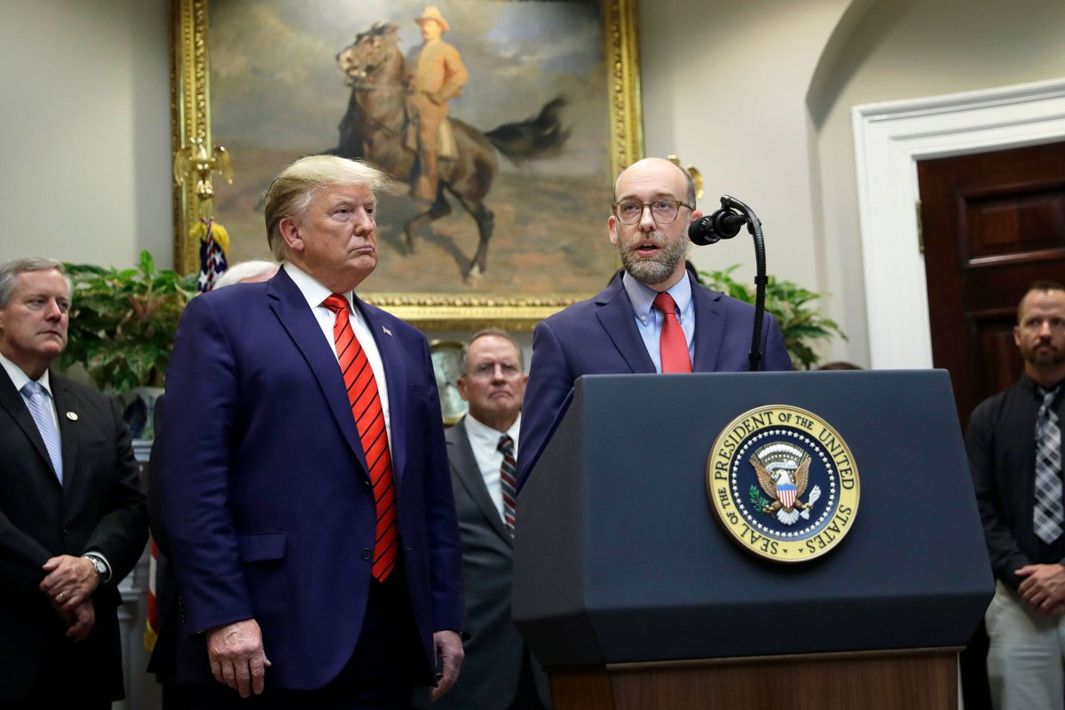 6 men in suits stand around a podium labeled President of the United States