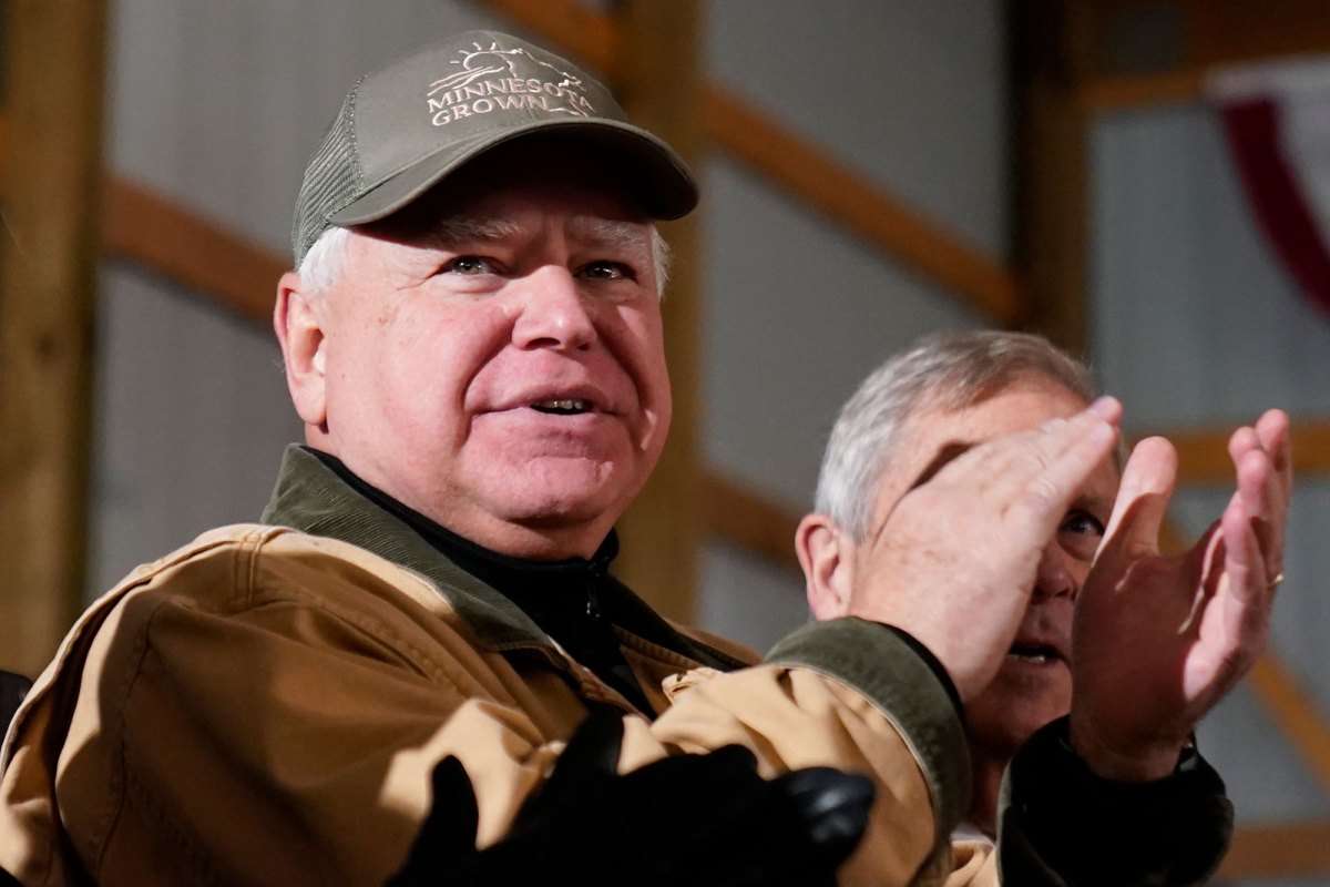 A man in a "Minnesota Grown" baseball cap claps