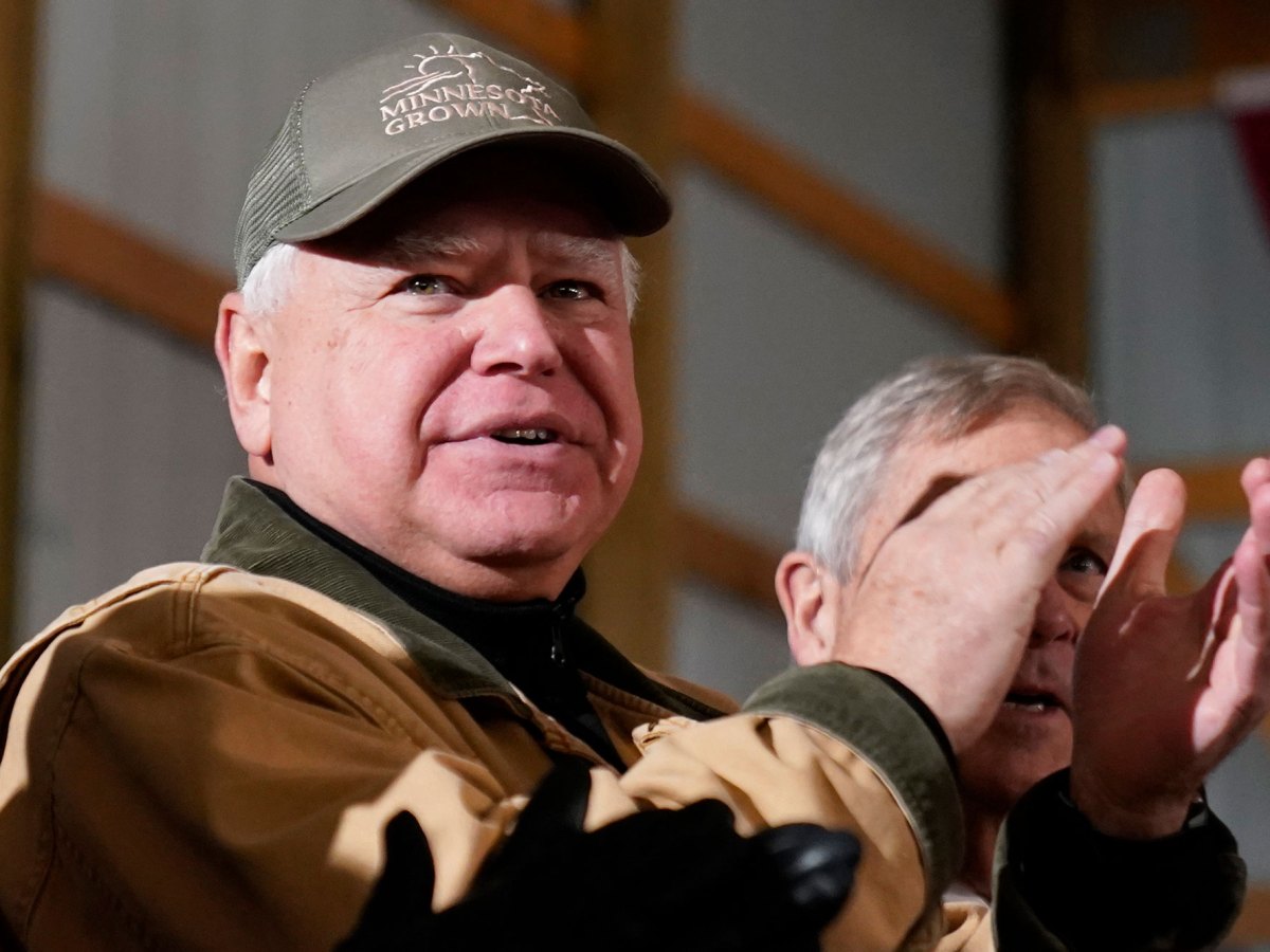 A man in a "Minnesota Grown" baseball cap claps