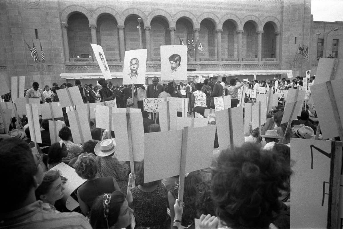 African American and white Mississippi Freedom Democratic Party supporters demonstrating outside the 1964 Democratic National Convention, Atlantic City, New Jersey; some hold signs with portraits of slain civil rights workers James Earl Chaney, Andrew Goodman, and Michael Schwerner