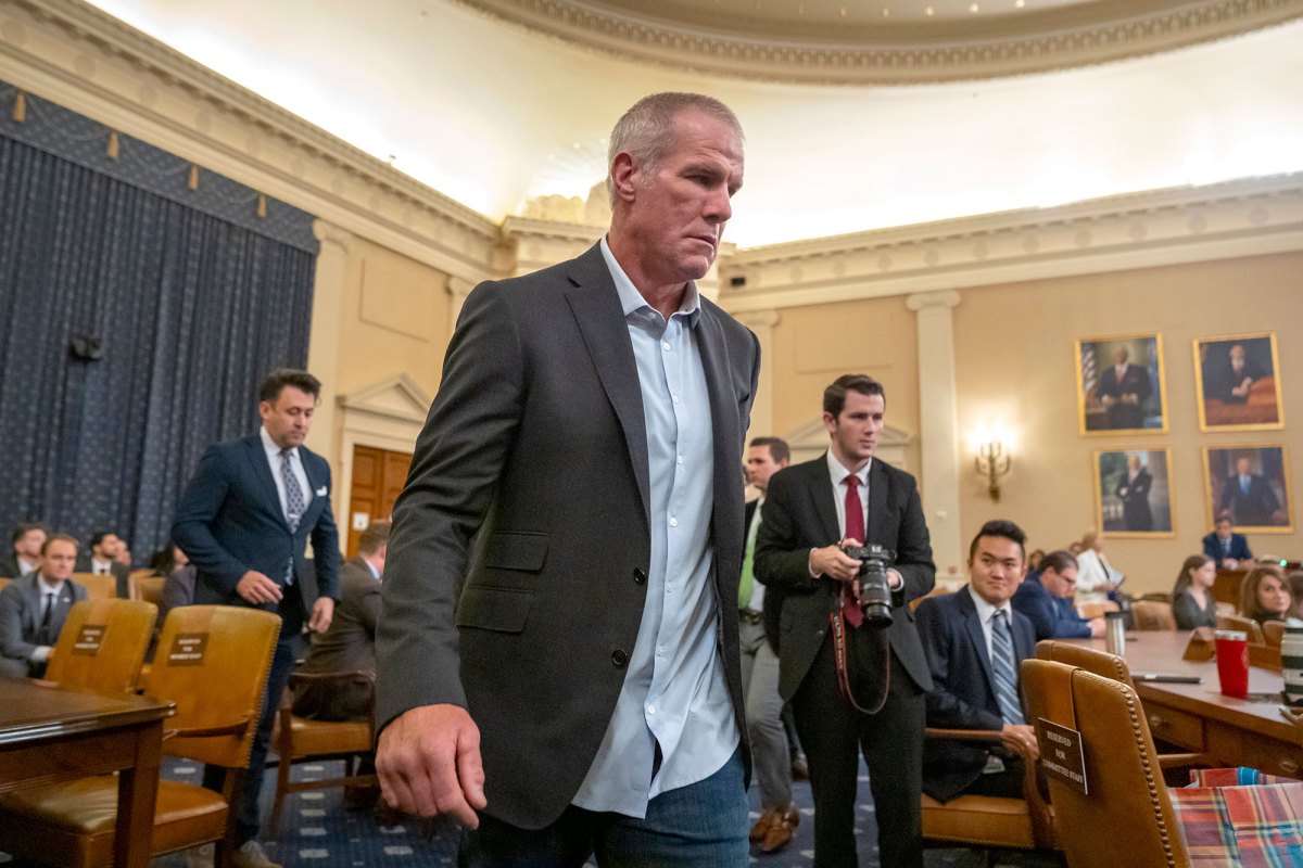 A man in a suit walks through a busy room